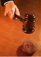 judges hand pounding gavel into base